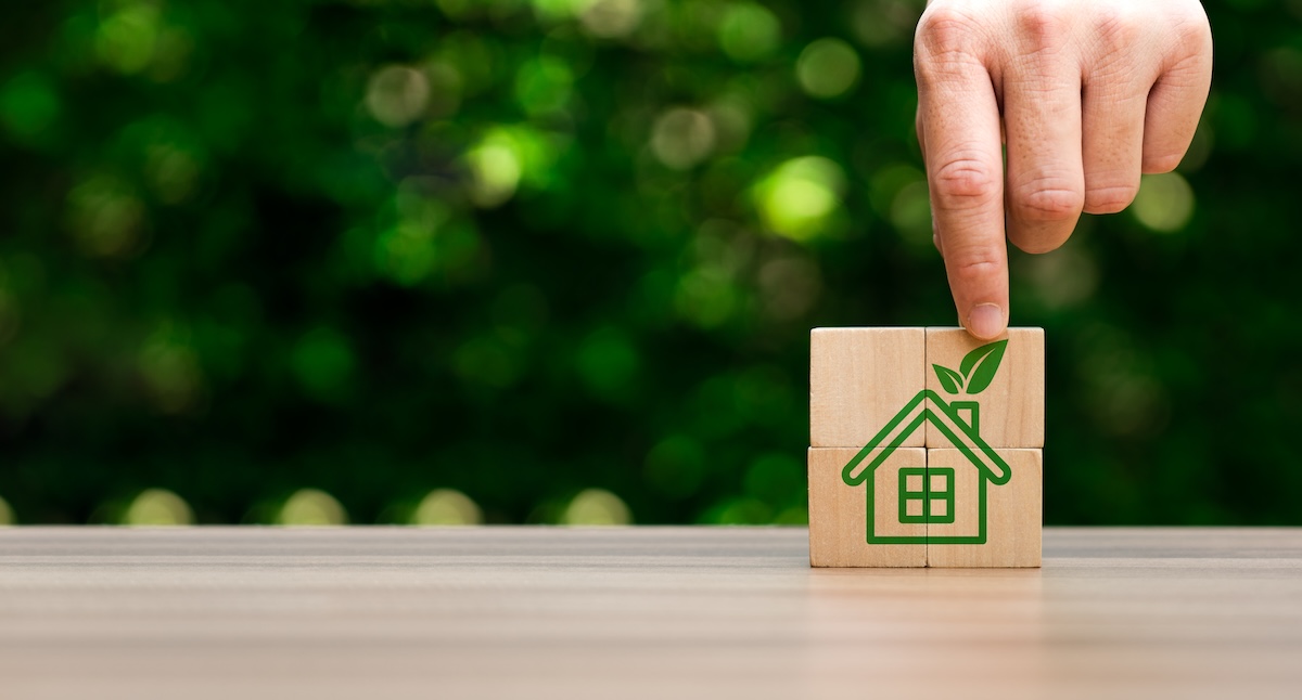 エコ住宅を象徴する木製ブロックと指先のアップ画像