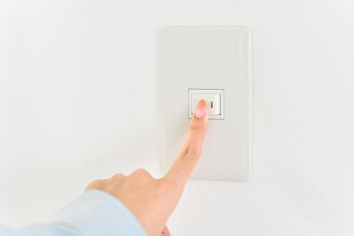 節電のために電気スイッチを消す手元のアップ写真
