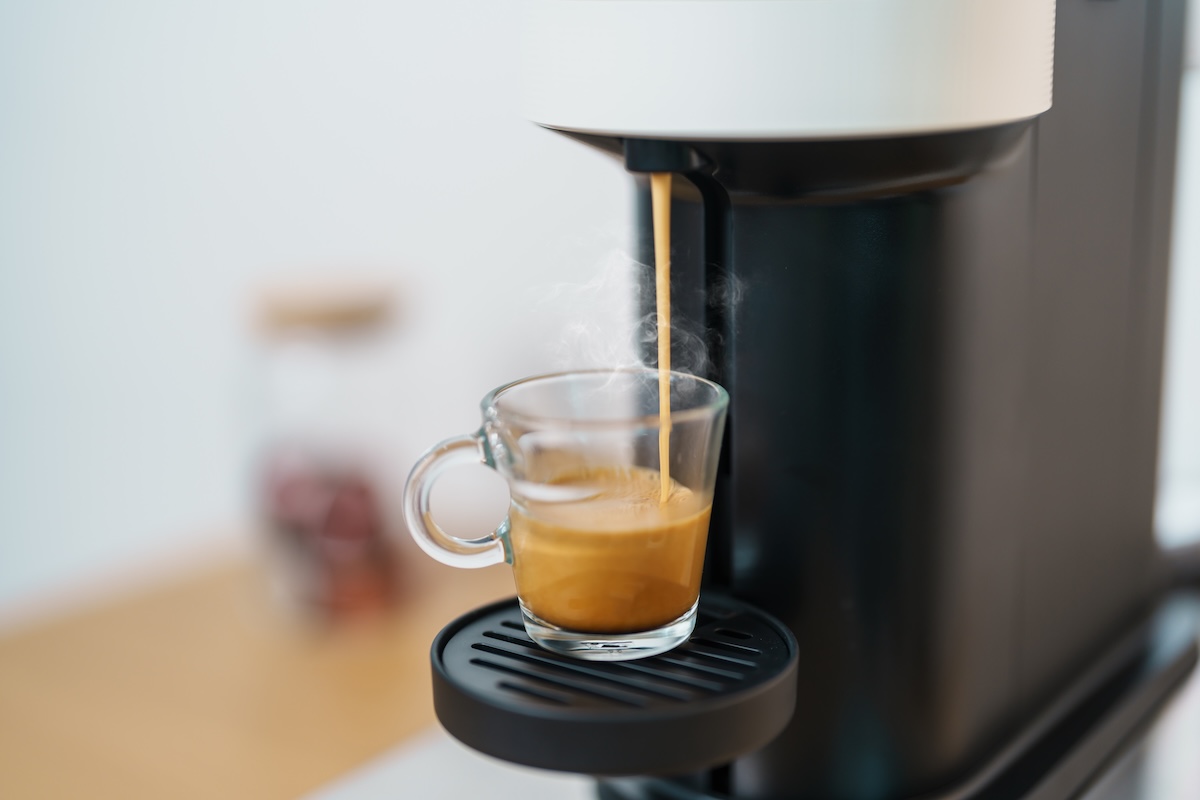 カプセル式コーヒーマシンから透明カップにエスプレッソが抽出される瞬間