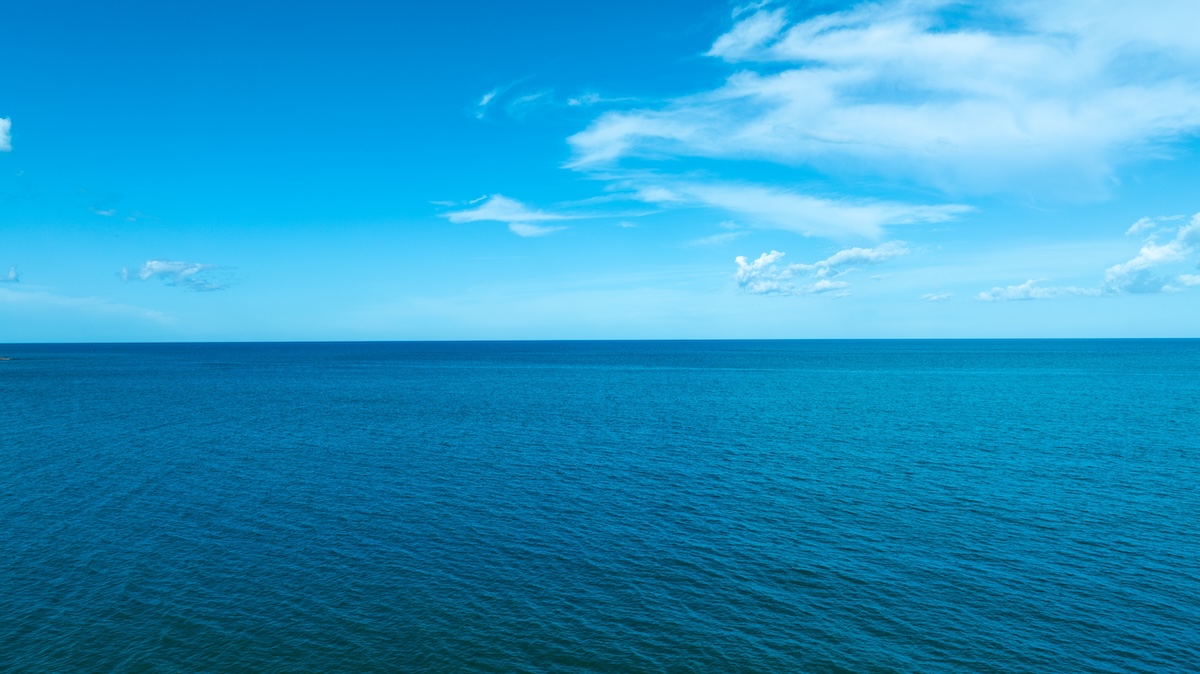 青空の下に広がる穏やかな青い海の水平線