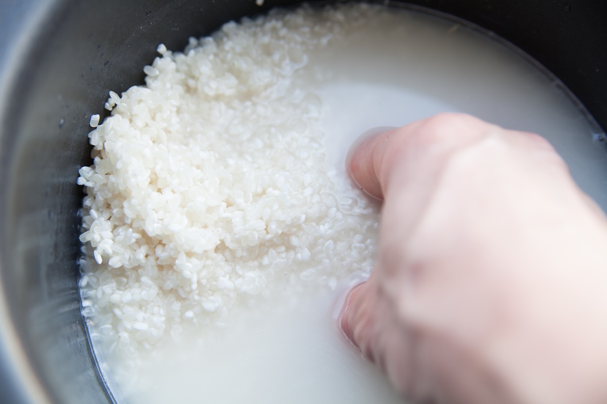 米のとぎ汁を流す様子。家庭からの生活排水がリンや窒素を含み、水質汚濁や富栄養化の一因となる。