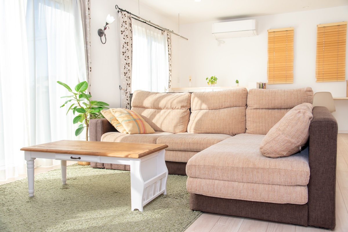 日当たりのよいリビングルームのソファ。自然光を活用した省エネ住宅のイメージ。