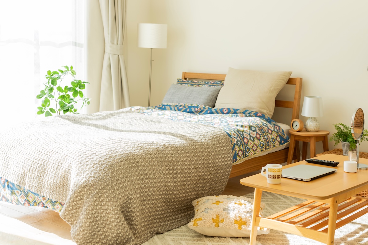 日差しが入る明るいベッドルームのインテリア（ベッドとローテーブル）