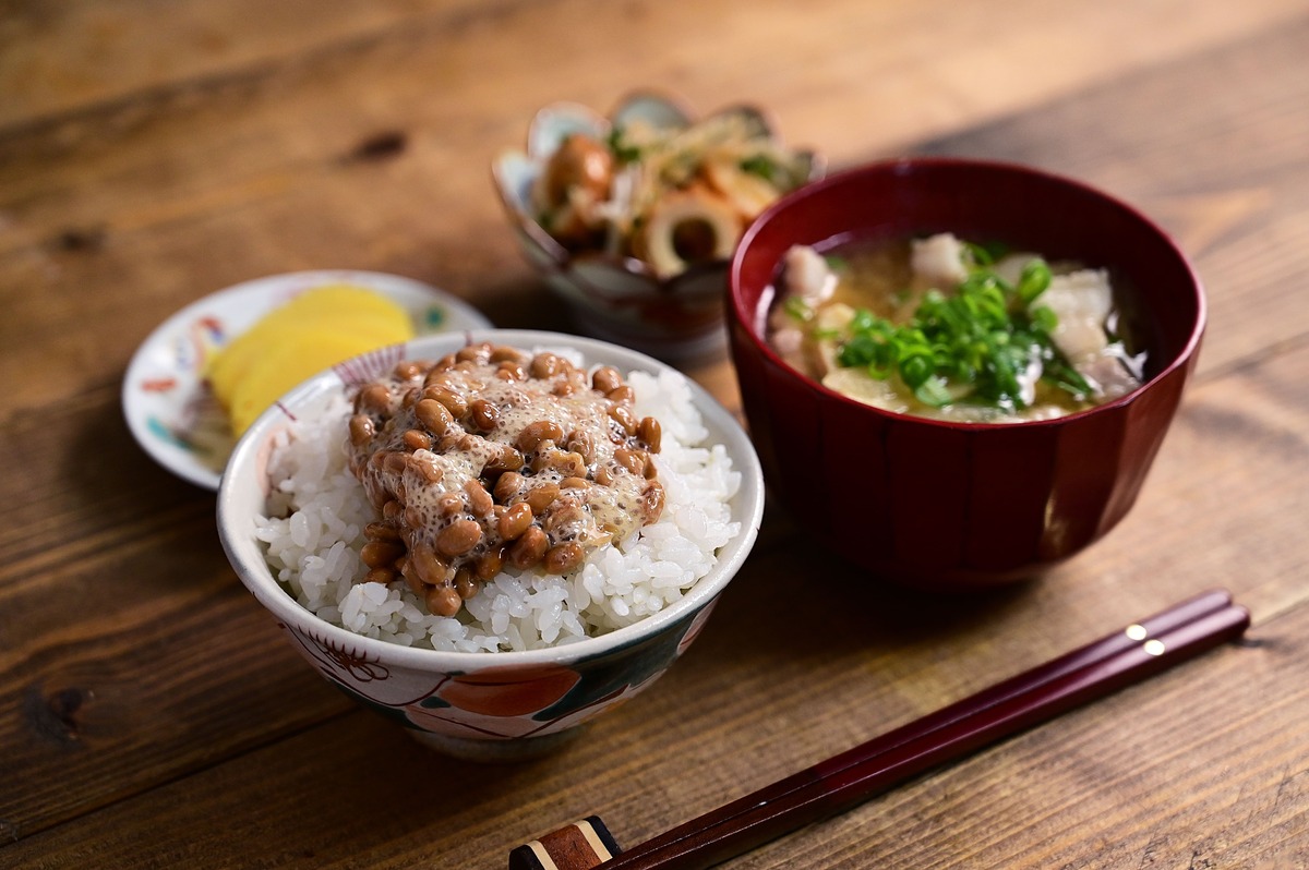 納豆ご飯・味噌汁・小鉢が並んだ和定食。大学生の一人暮らしの自炊を示すイメージ。